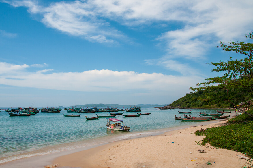 Phu Quoc beach with sand and Vietnamese boats at sea